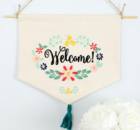 Welcome a new friend or neighbor by adding this free welcome wreath embroidery design to a dishtowel, banner, pillow or flag. #freeembroiderydesign #embroiderydesign